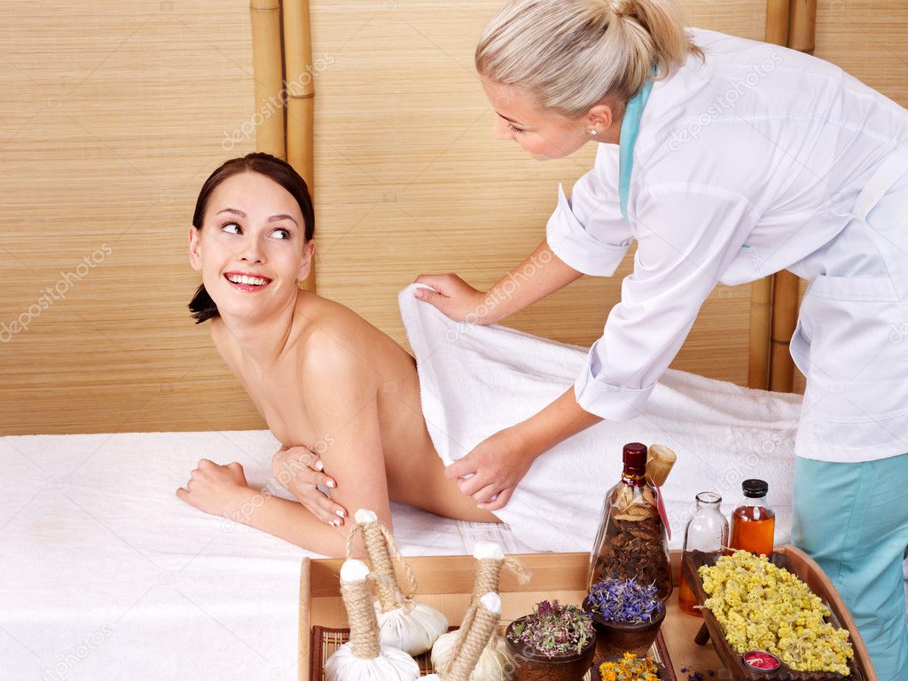 Young woman on massage table in beauty spa.
