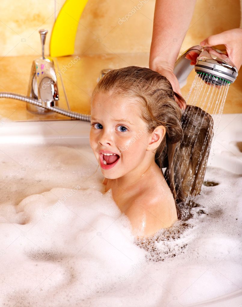 Kid washing hair by shampoo .