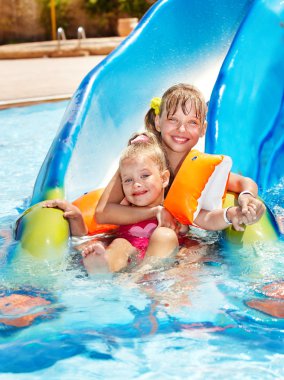 Children on water slide at aquapark. clipart