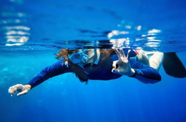 Scuba diver woman in blue water. clipart