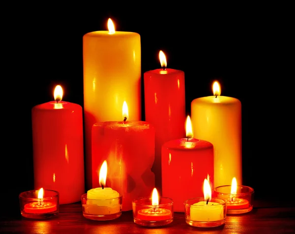 Gruppo di candele su sfondo nero . — Foto Stock
