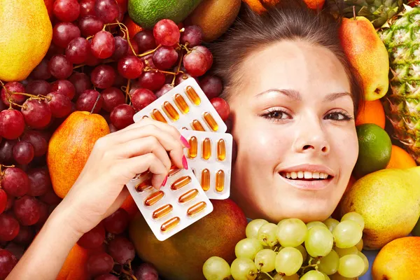 Mujer con píldora de frutas y vitaminas . —  Fotos de Stock