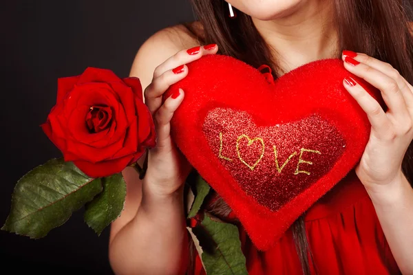Mädchen mit Herz und Blume Rose auf rotem Hintergrund. — Stockfoto