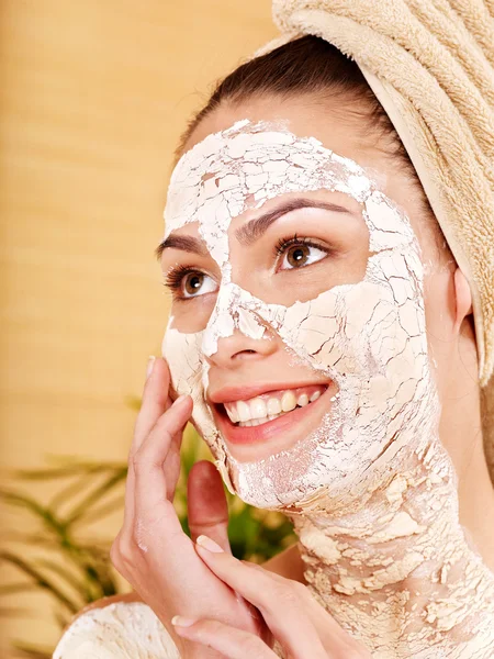 Jonge vrouw met klei gezichtsmasker. — Stockfoto