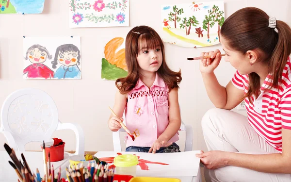 Kind met leraar tekenen verven in speelkamer. — Stockfoto