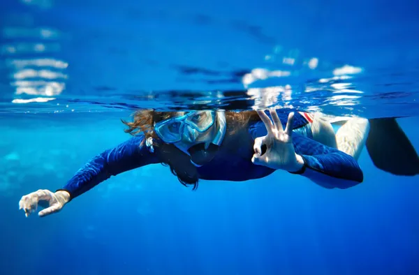 Scuba diver žena v modré vodě. — Stock fotografie