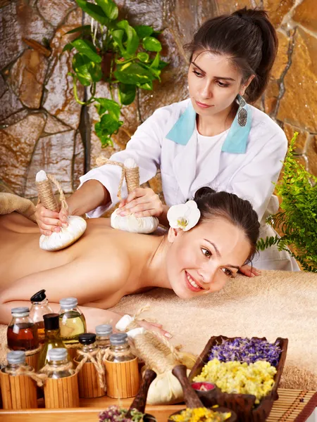 Woman getting thai herbal compress massage . Stock Image