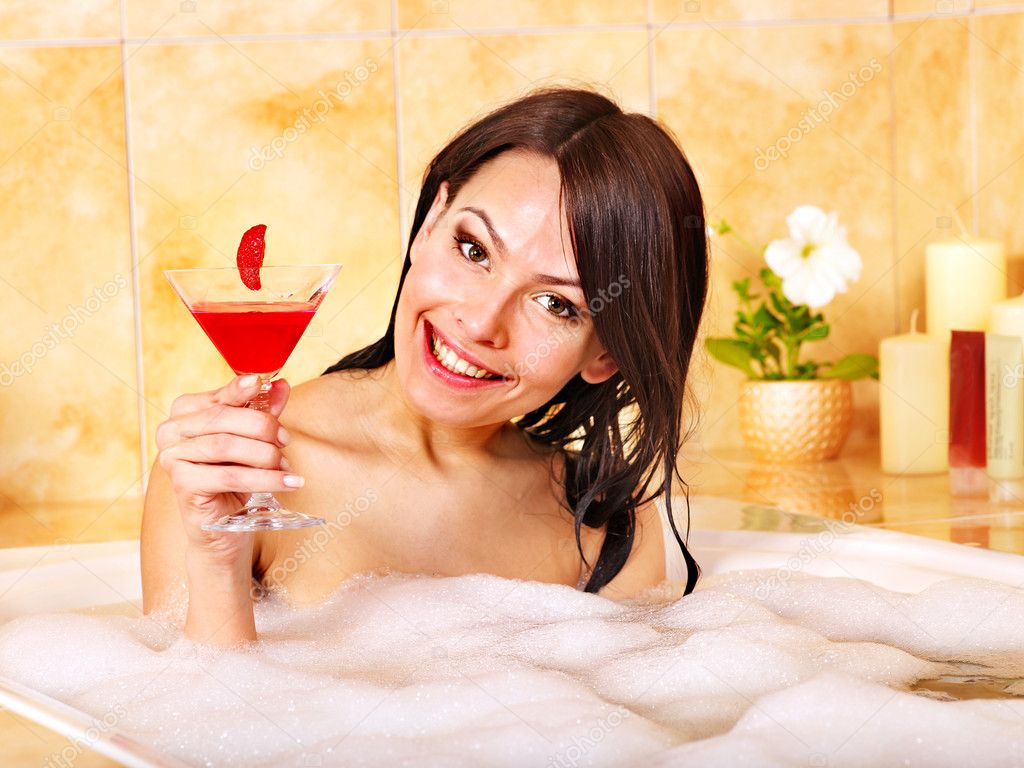 Woman washing in bubble bath.