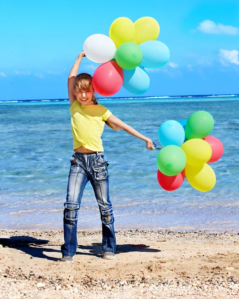 Criança brincando com balões na praia — Fotografia de Stock