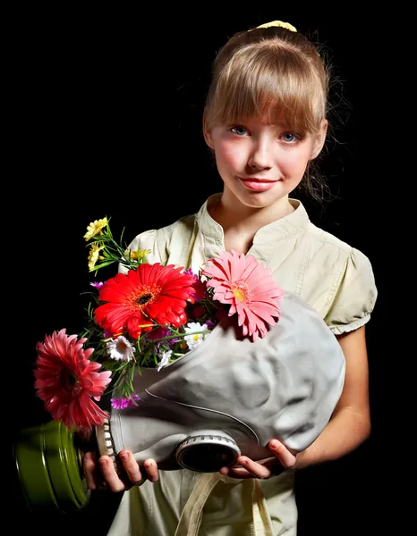 Dítě drží květiny a plynovou masku . — Stock fotografie