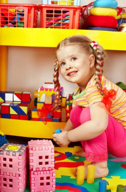 Child playing with building block . clipart