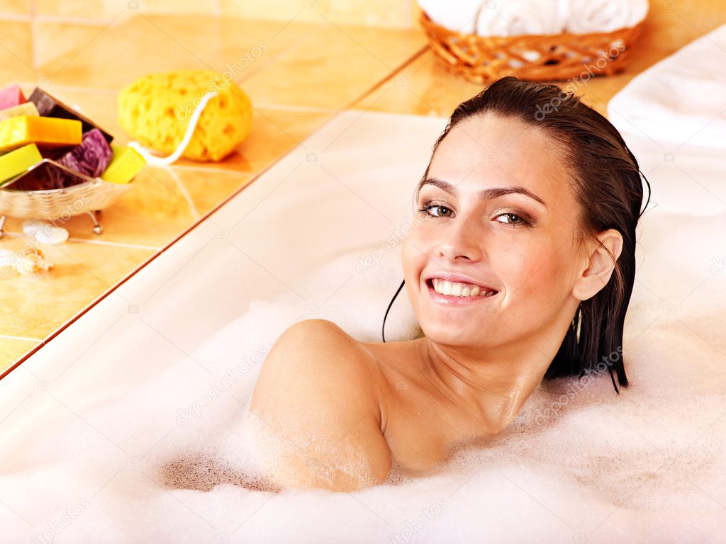 Woman relaxing in bubble bath .