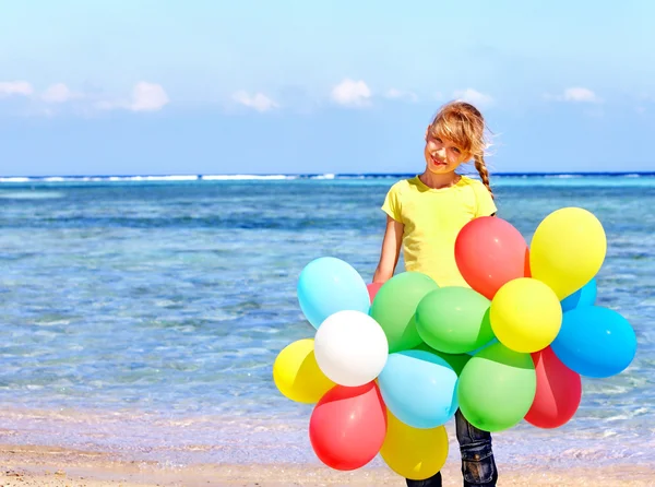 Criança brincando com balões na praia . — Fotografia de Stock