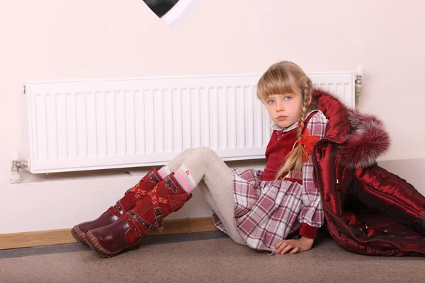 Girl in coat warm near radiator. Crisis. — Stock Photo, Image