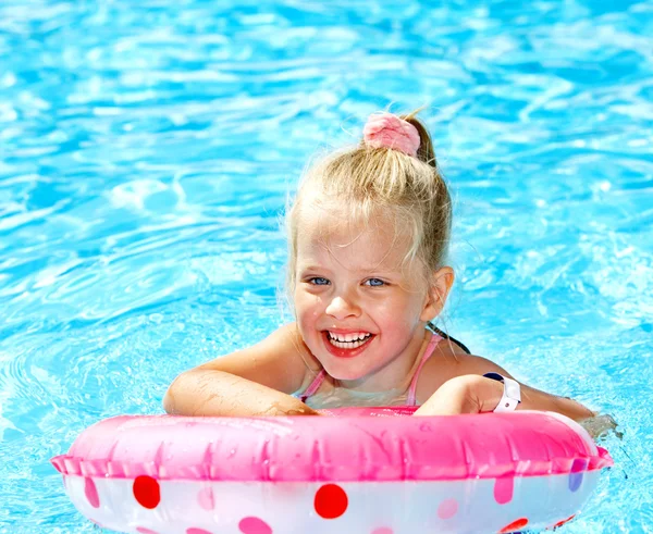 Niño sentado en anillo inflable en la piscina . — Foto de Stock