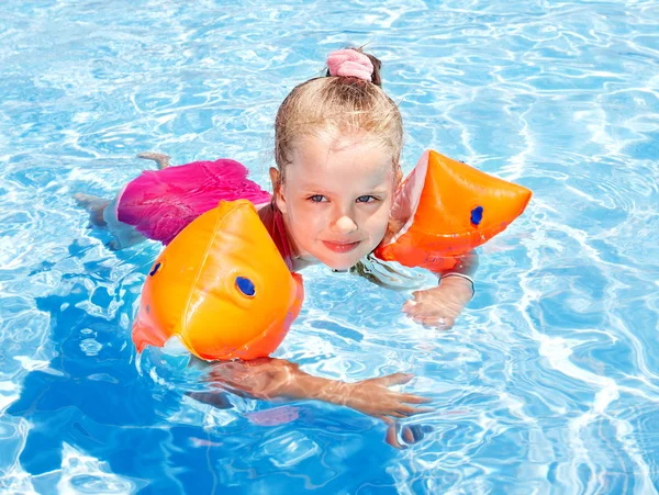 Criança com braçadeiras na piscina . — Fotografia de Stock