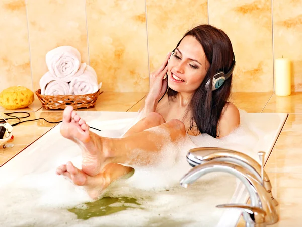Женщина слушает музыку в ванне с пеной . — стоковое фото