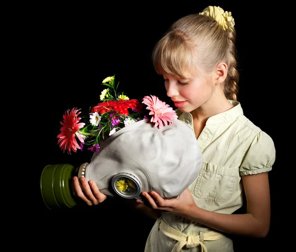 Ребенок держит цветы и противогаз  . — стоковое фото