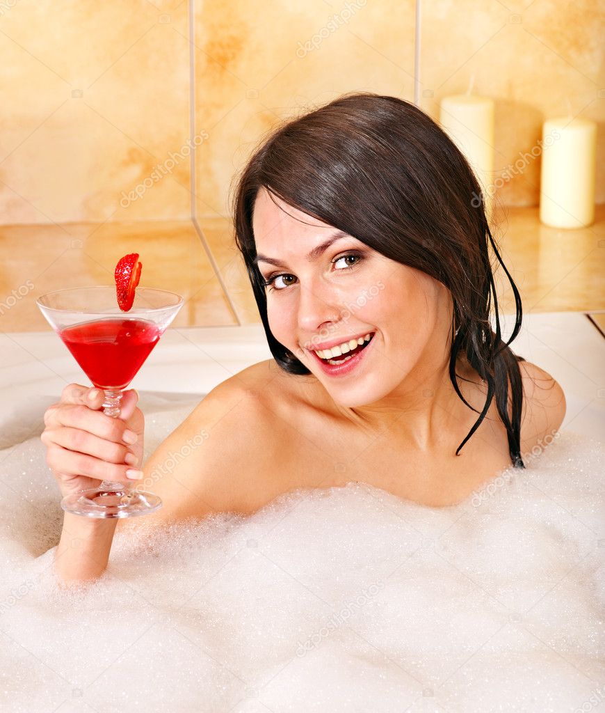 Woman washing in bubble bath.
