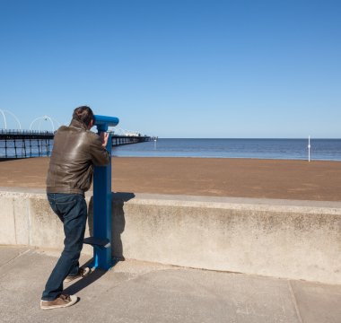 Senior man looking out over beach at Southport clipart