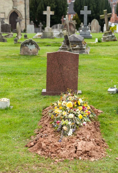 Свежевырытая могила на кладбище — стоковое фото