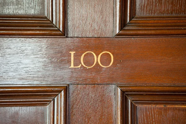 Loo stencilled onto door to bathroom — Stock Photo, Image