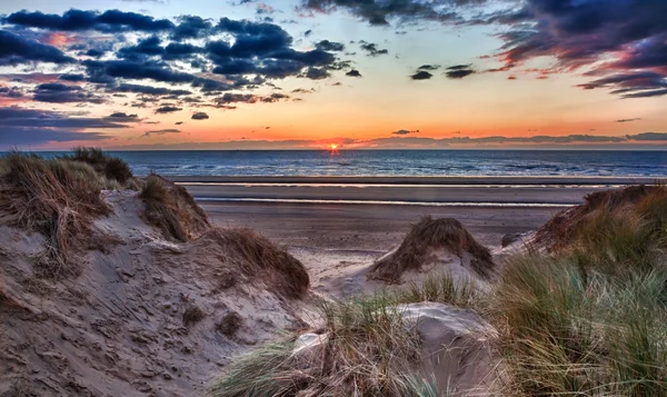Solnedgang over Formby Beach gjennom sanddyner – stockfoto