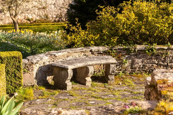 Vecchia panca in pietra intagliata in giardino — Foto Stock