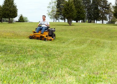 Senior man on zero turn lawn mower on turf clipart