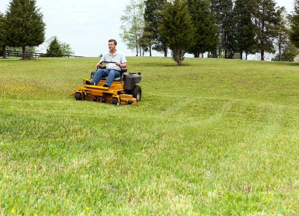 Senior man on zero turn lawn mower on turf — Stock Photo, Image