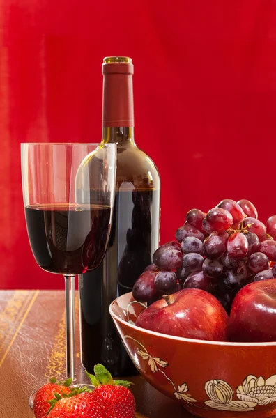 Kırmızı şarap şişe ve cam ile meyve — Stok fotoğraf