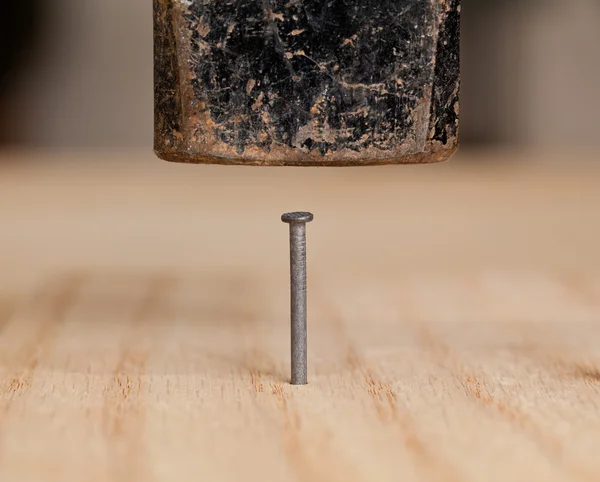 Nagel mit Hammer ins Holz geschlagen — Stockfoto
