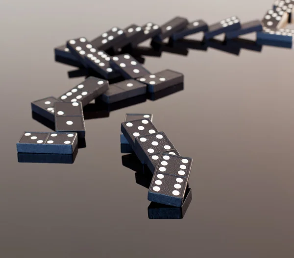 Dominoes collapsed on reflective surface — Stock Photo, Image