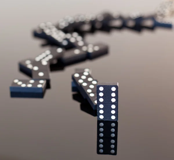 Dominoes collapsed on reflective surface — Stock Photo, Image