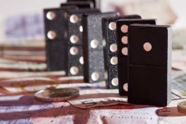 Standing dominoes on bank notes clipart