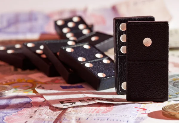 stock image Fallen dominoes on bank notes