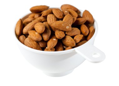 Raw organic almonds in measuring cup clipart