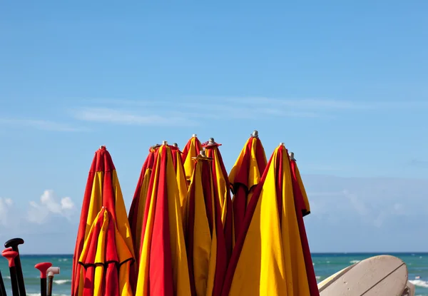 Strand parasols vastgebonden aan kust — Stockfoto