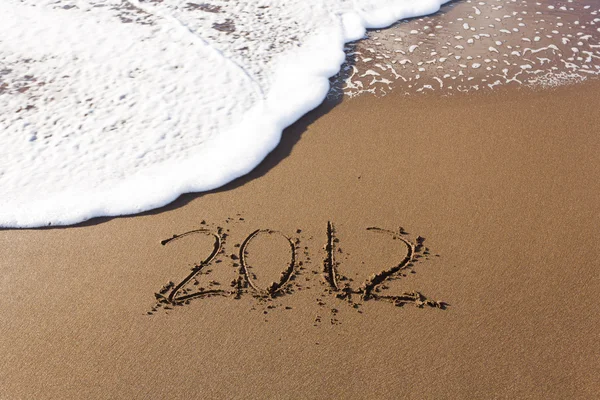 2012 scritto in sabbia con onde — Foto Stock