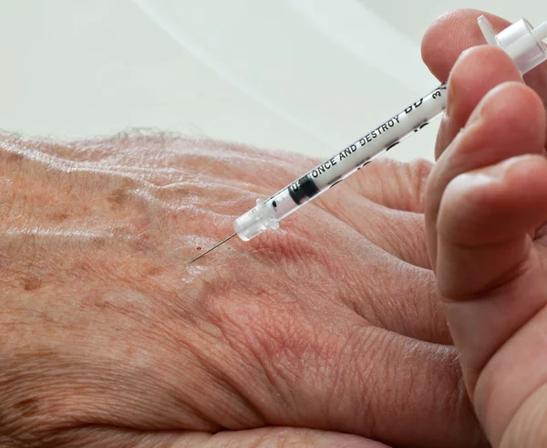 Injekce do rukou starší muž — Stock fotografie