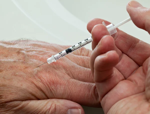 Injection into hand of senior male — Stock Photo, Image