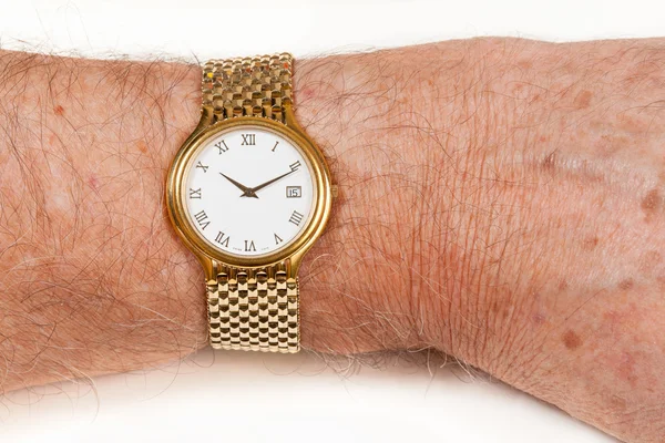 Zlaté hodinky s bílou tváří na chlupatý zápěstí — Stock fotografie