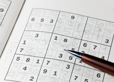 Pencil resting on sudoku book clipart