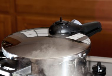 Pressure being released from cooker on hob clipart