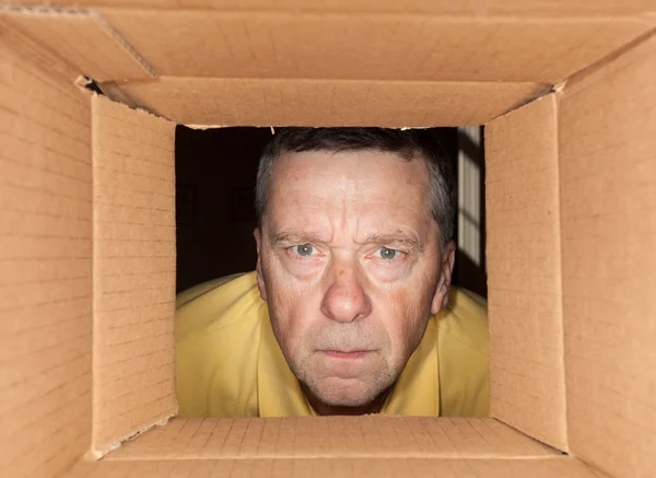 Homem sênior olhando para a caixa de papelão — Fotografia de Stock