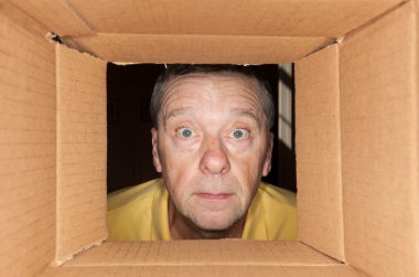 Senior man staring into cardboard box clipart