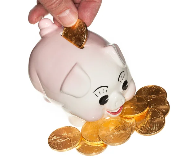 Piggy Bank aranyérme elhelyezése kézzel — Stock Fotó