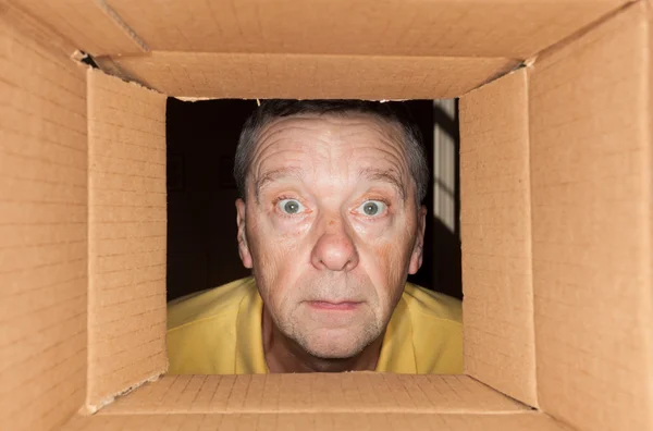 Ανώτερος άνθρωπος, κοιτάζοντας στο κουτί από χαρτόνι — Φωτογραφία Αρχείου