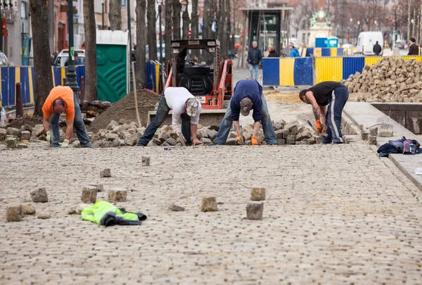 Arbeiders bouwen geplaveide straat in Brussel — Stockfoto