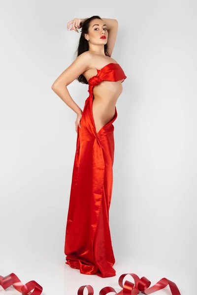 Hermosa mujer joven está cubierta de tela roja . — Foto de Stock